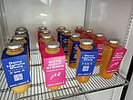 Ermutigung & Vitamine in Form von TrueFruits Smoothies 16 orangene Smoothies mit blau oder pinkem ZA-Schild mit Spruch