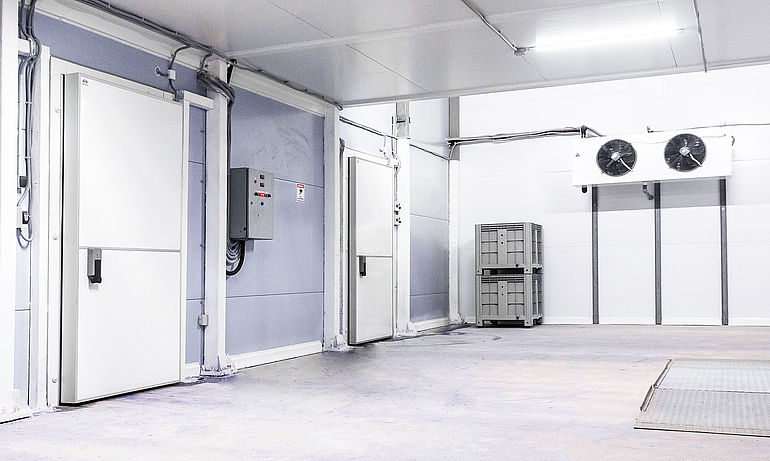 two axial fans with white housing in empty cooling chamber