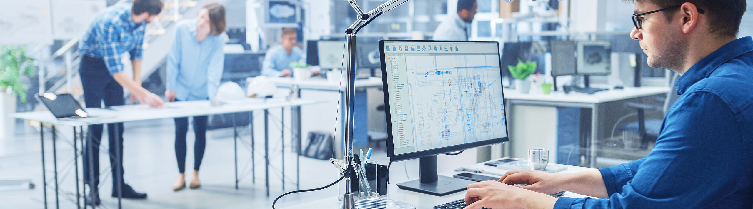 Research and development persons working in a development laboratory man with blue shirt on PC