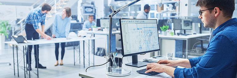 Research and development persons working in a development laboratory man with blue shirt on PC