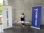 Unterstützung in der Prüfungszeit ZIEHL-ABEGG Aufsteller & Tisch mit Merchandise vor Mitarbeiterin