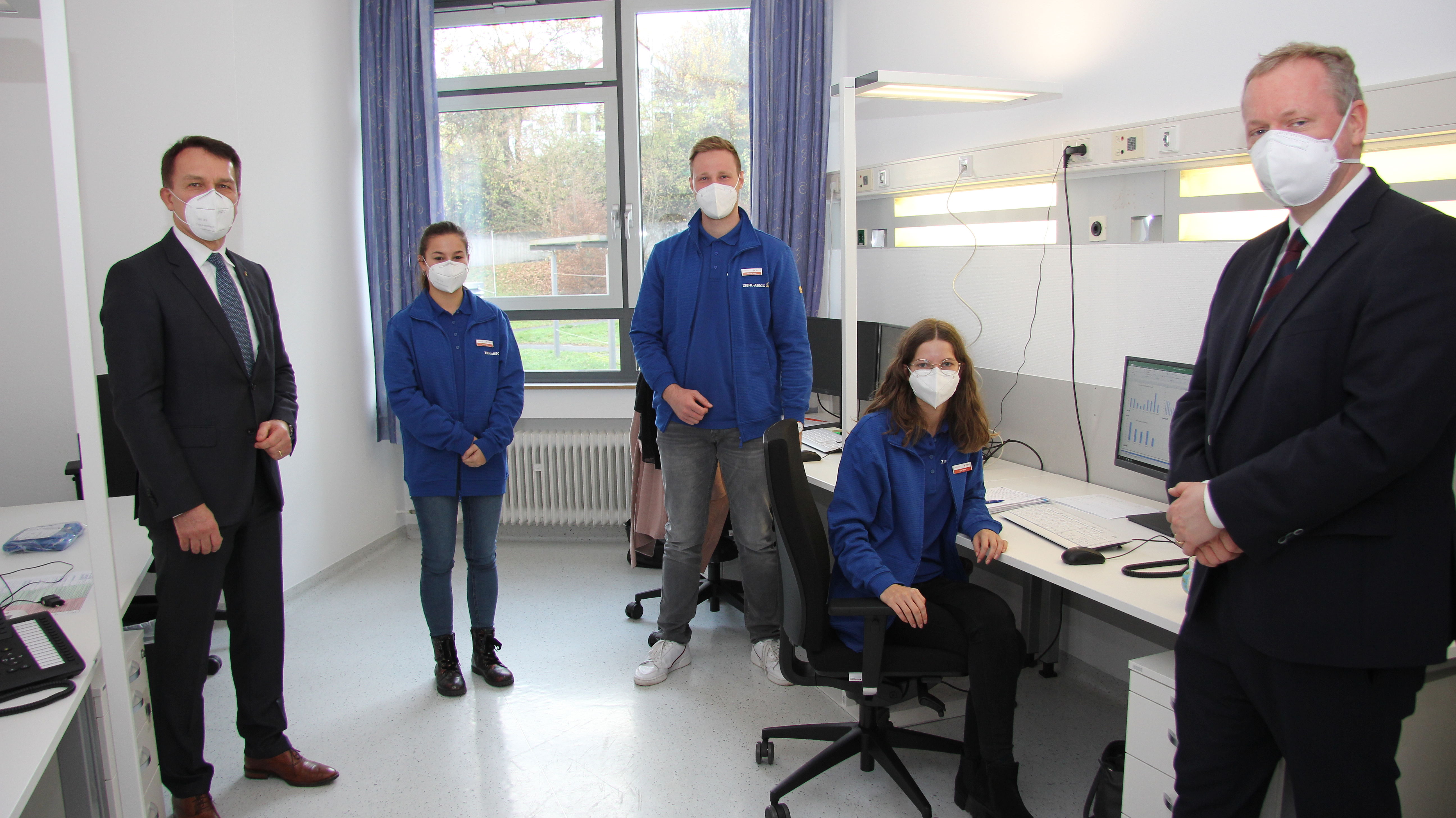 Corona-Hotline managen statt bei Ziehl-Abegg Industrieluft schnuppern: Isabel Joos (Zweite von links), Marcel Nohe und Lisa Ehret in Gesundheitsamt Künzelsau; flankiert von Firmenchef Peter Fenkl und Landrat Dr. Matthias Neth (rechts).