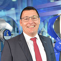 Klaus Amon Geschäftsführer ZIEHL-ABEGG Frankreich Klaus Amon mit schwarzem Anzug, roter Krawatte & Brille