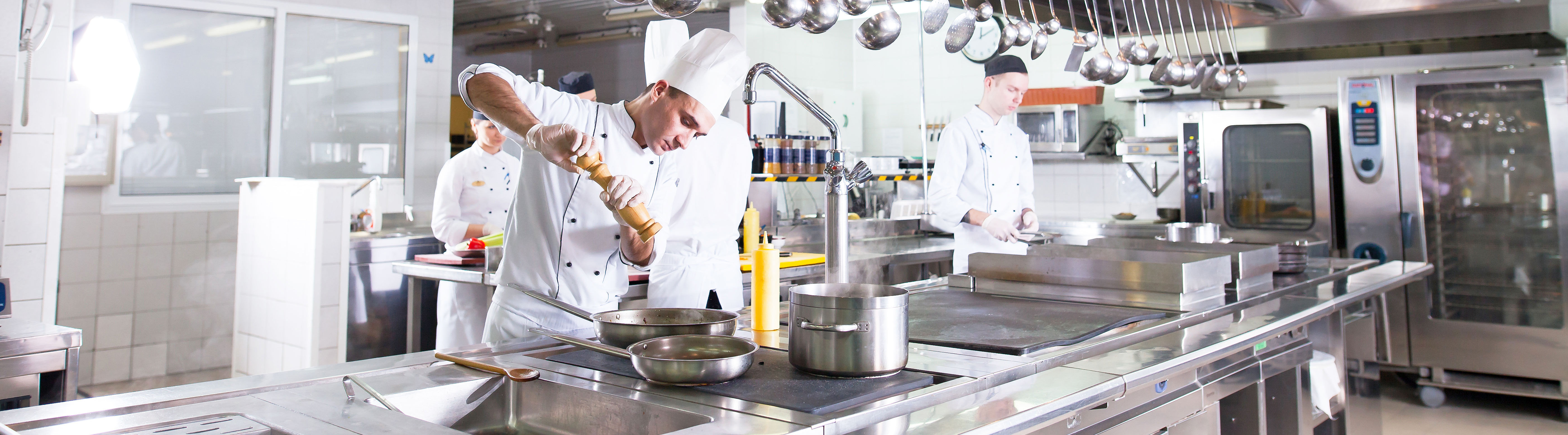 five cooks in industrial kitchen