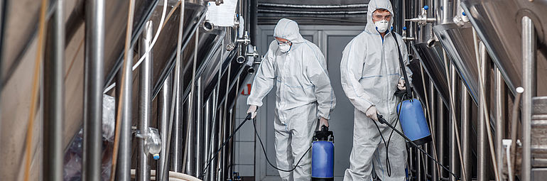 04-beverages two persons in hygienic protective clothing clean production machine for beverages