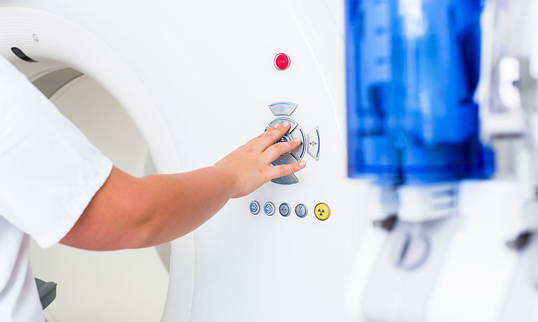 medical equipment technology person operates computer tomographs