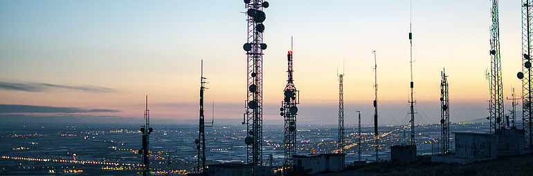 transmission towers with big city in the background