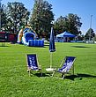 Sponsoring beim Sportverein Liegestühle, Schirm, Hüpfburg & Pavillon auf grüner Wiese