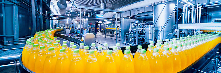Roller conveyor in filling line bottles with yellow lemonade