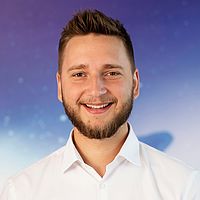 Marek Giňa mit braunem Haar & Bart & weißem Hemd