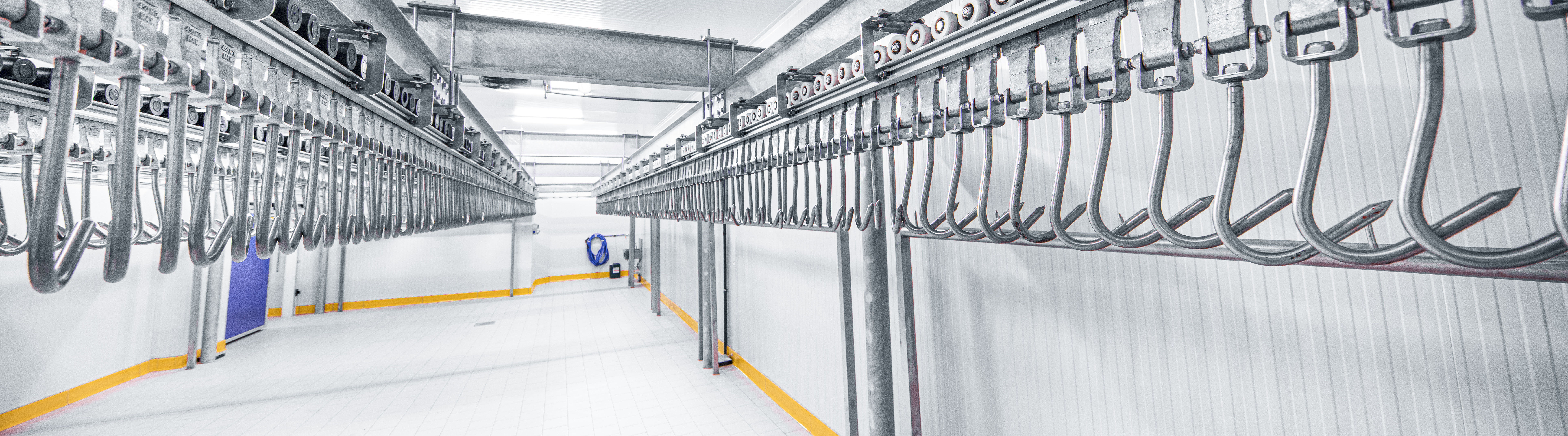 Row of meat hooks in empty cooling chamber