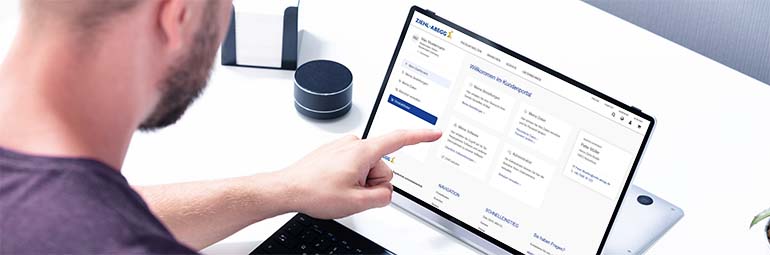 ZIEHL-ABEGG Kundenportal Person vor einem Laptop mit geöffnetem ZIEHL-ABEGG Kundenportal