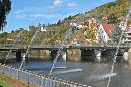 Kocher in Künzelsau River with water fountains and bridge in background