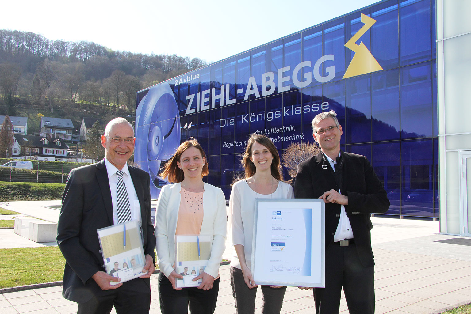 At Ziehl-Abegg, the IHK representatives Franz Henschel (left) and Michael Hilsmann present the “Dualis” certificate for training to the people in charge of training Jenny Wacker (centre left) and Lena Göller.