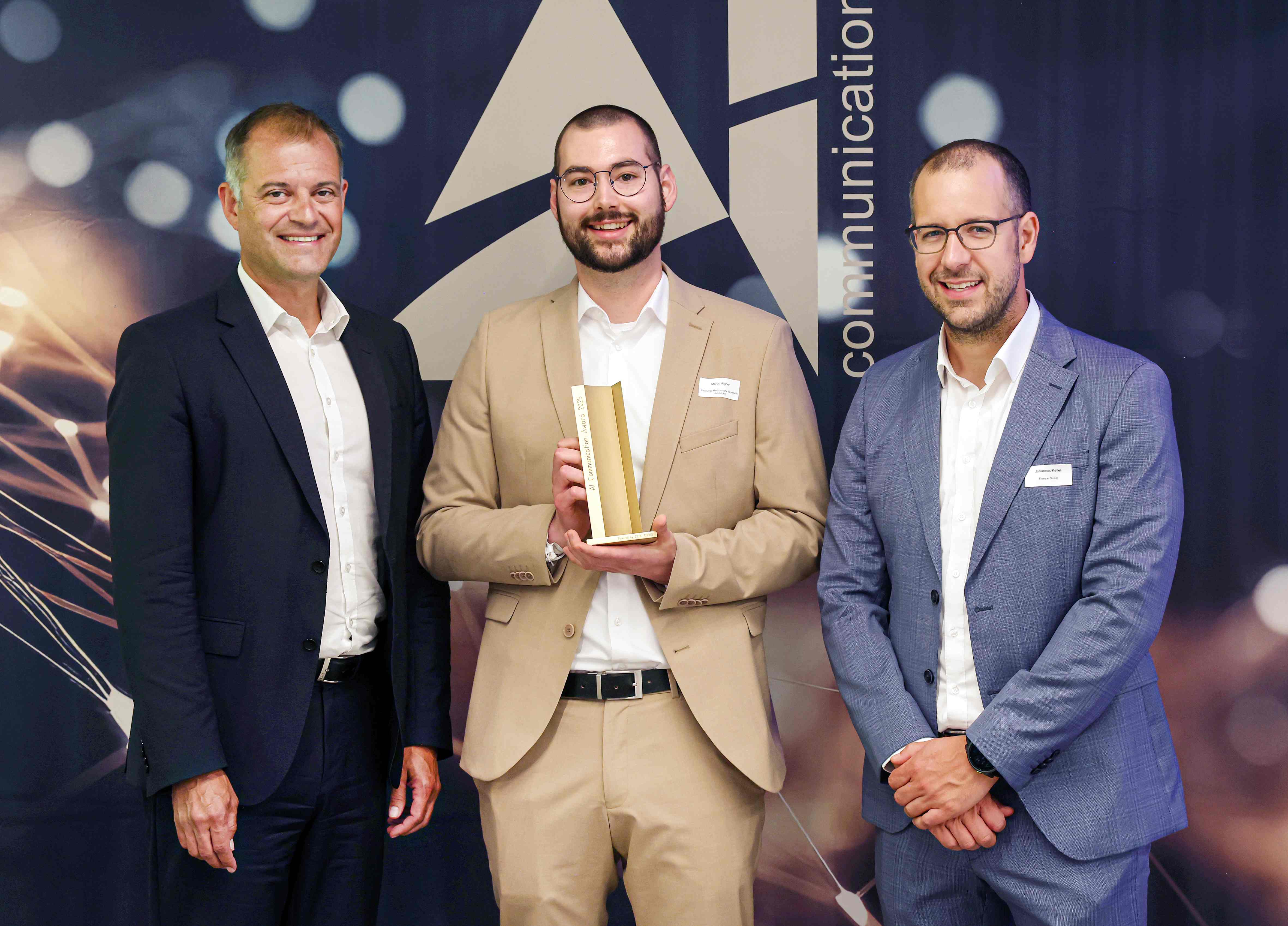 Joachim Ley (CEO of Ziehl-Abegg, left) presents the award with jury chair Johannes Keller (right) to Marco Florian Aigner (University of Heidelberg & Heilbronn University).